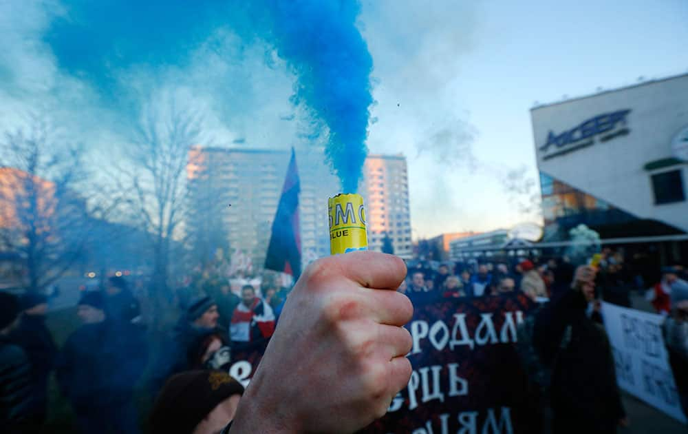 A Belarusian opposition protester holds a lighted flare during a rally in Minsk, Belarus.