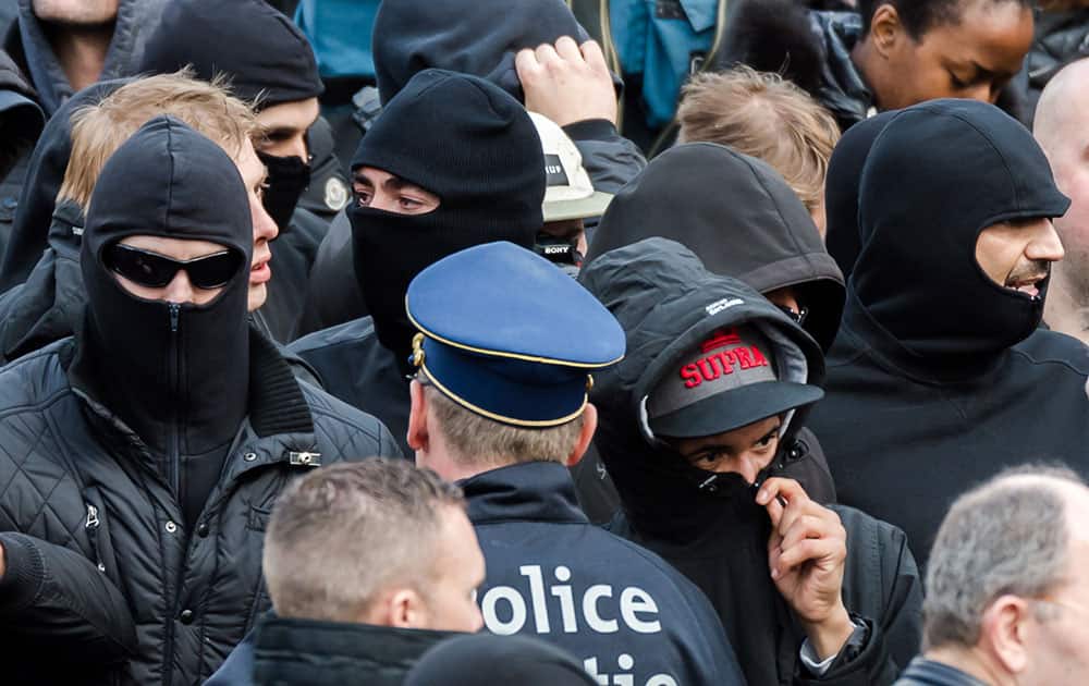 Right wing demonstrators talk with a police man as they protest at a memorial site at the Place de la Bourse in Brussels.