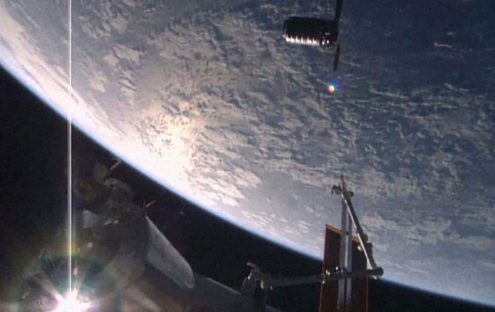 In this image made from video provided by NASA, Orbital ATKs Cygnus cargo ship, top, approaches the International Space Station.