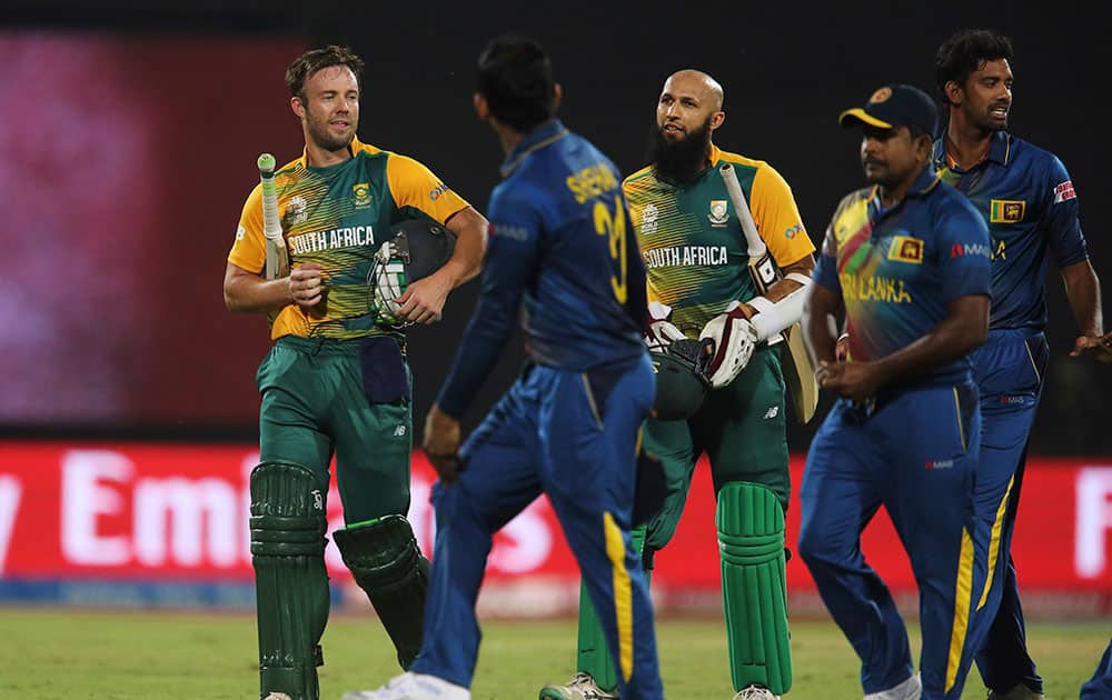 South Africa's Hashim Amla, center and AB de Villiers, left, return after winning against Sri Lanka during their ICC Twenty20 2016 Cricket World Cup match at the Feroz Shah Kotla Cricket Stadium in New Delhi.