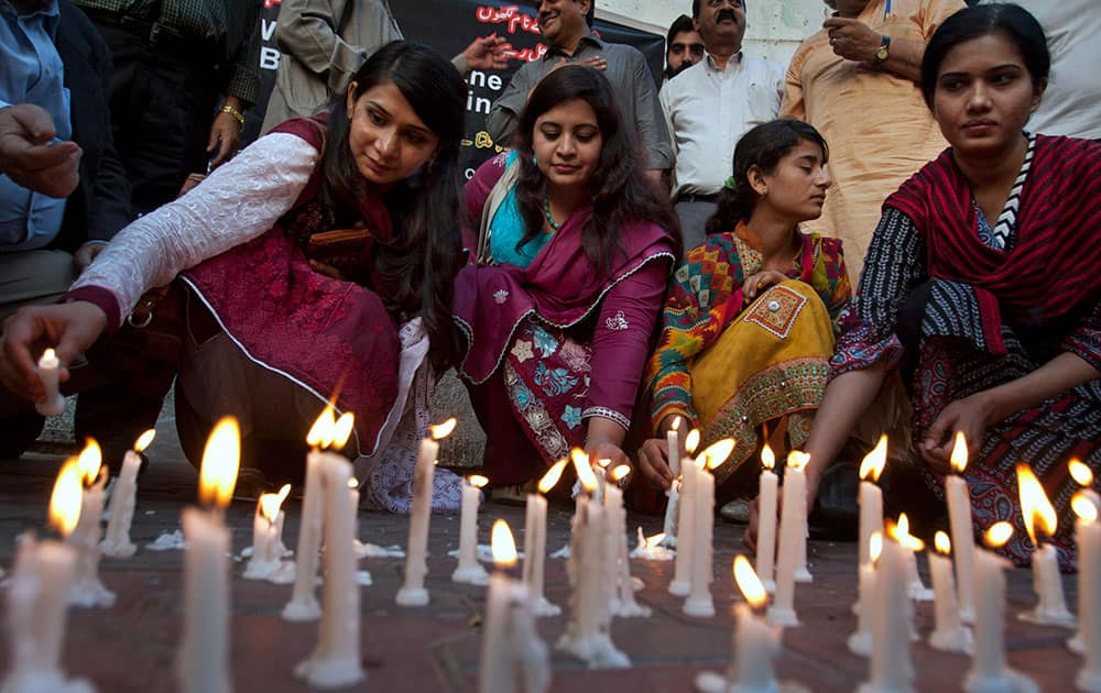 Members of a civil society group light candles during a vigil for the victims of Sunday's suicide bombing, in Karachi, Pakistan.