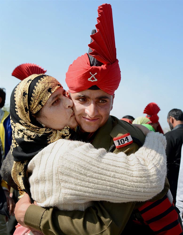 A woman embraces her son during the pipping ceremony after Passing Out parade at JKLIRC Army Headquaters in Srinagar on Tuesday. As many as 145 Kashmiri youth formally joined Army after Attestation cum Passing out Parade. 
