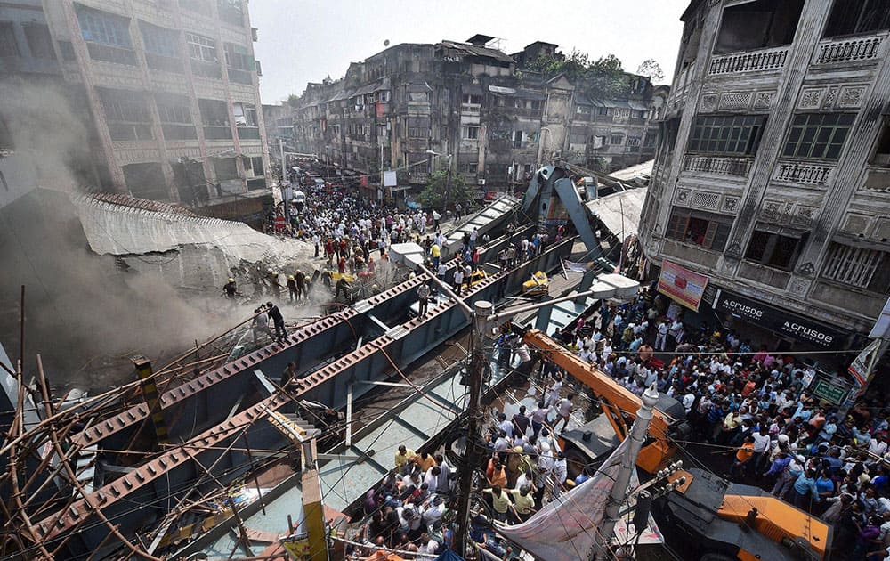 Locals and rescue workers clear the rubbles of a partially collapsed overpass in Kolkata.