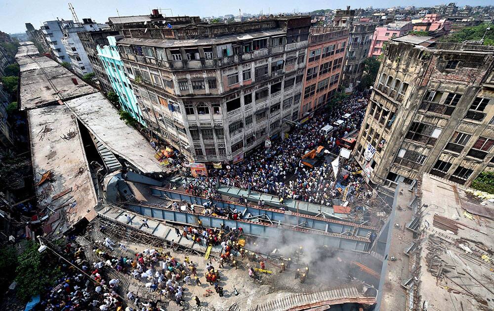 Locals and rescue workers clear the rubbles of a partially collapsed overpass in Kolkata.