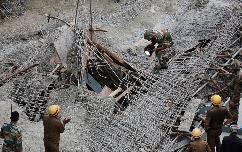 An Indian soldier looks for survivors under a partially collapsed overpass in Kolkata.