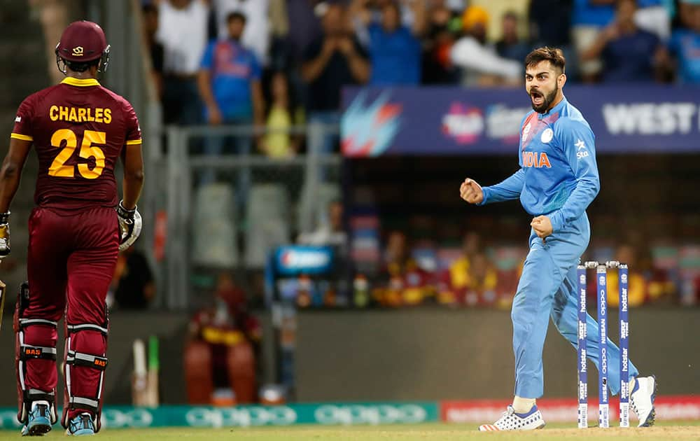 Virat Kohli celebrates after taking the wicket of West Indies Johnson Charles, left, during their ICC World Twenty20 2016 cricket semifinal match at the Wankhede stadium in Mumbai.