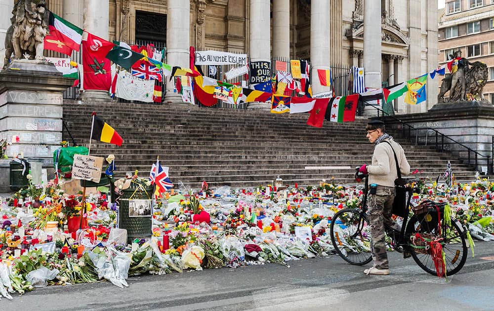 A man looks at a memorial site for the victims of the Brussels attacks at the Place de la Bourse in Brussels, Belgium.