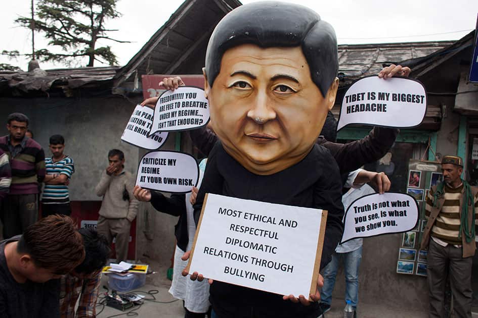 A Tibetan activist wears a mask in the likeness of the Chinese president Xi Jinxing during a street protest in Dharmsala.