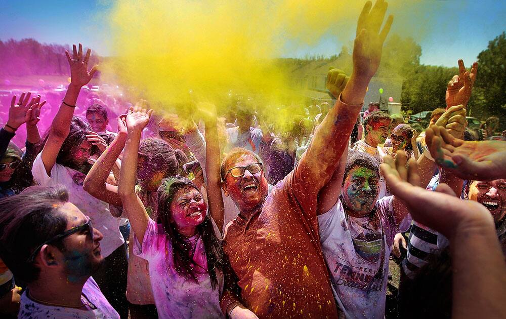 A crowd of celebrants toss colored powder into the air during the Festival of Colors at the India Cultural Center and Temple in Memphis, Tenn.