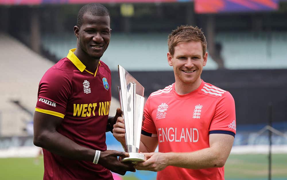 West Indies’ captain Darren Sammy, left, and England's captain Eoin Morgan pose with the winner's trophy a day ahead of their final match of the ICC World Twenty20 2016 cricket in Kolkata.