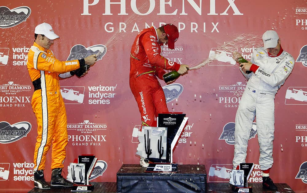 Scott Dixon, middle, of New Zealand, celebrates with Simon Pagenaud, left, of France, and Will Power, of Australia, after winning the IndyCar Phoenix Grand Prix auto race at Phoenix International Raceway in Avondale, Ariz.
