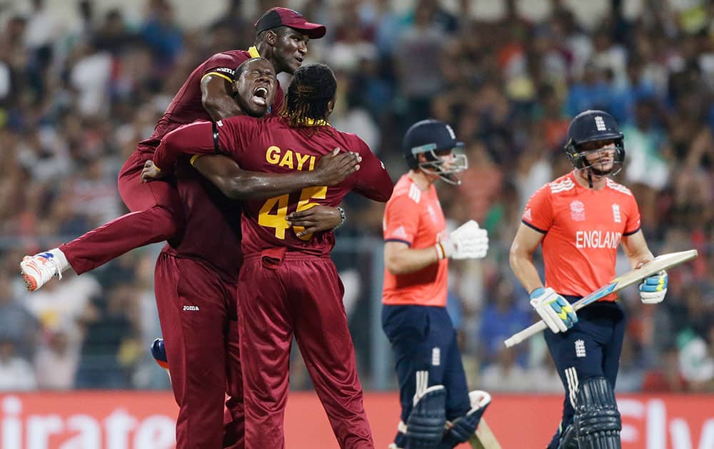 West Indies’ players Darren Sammy, Carlos Brathwaite and Chris Gayle celebrate the dismissal of England's Jos Buttler, right, during the final of the ICC World Twenty20 2016 cricket tournament at Eden Gardens in Kolkata.