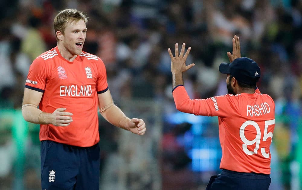 England's Adil Rashid congratulates teammate David Willey after taking the wicket West Indies Darren Sammy during the final of the ICC World Twenty20 2016 cricket tournament at Eden Gardens in Kolkata.