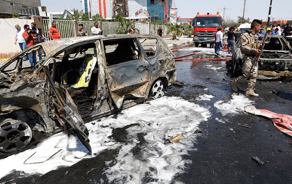 Iraqi security forces inspect the scene of a suicide car bomb attack in Basra, Iraq's second-largest city, 340 miles (550 kilometers) southeast of Baghdad, Iraq.