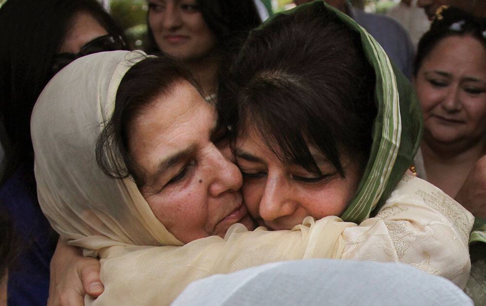 Kashmir Chief Minister Mehbooba Mufti, right, hugs her mother Gulshan Ara Nazir after Mufti took the oath of office during a ceremony in Jammu.