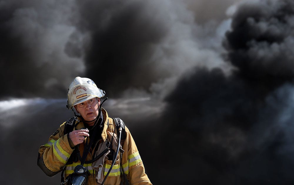 Firefighters work to contain a fire that started at a metal recycling business, in Montclair, Calif. 