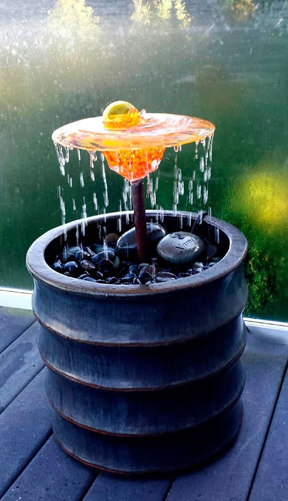 This photo provided by Glass Gardens NW shows a glass fountain by Seattle area glass blower Barbara Sanderson, who crafts beautiful flowers, fountains and sculptures that can be placed in gardens and water features.