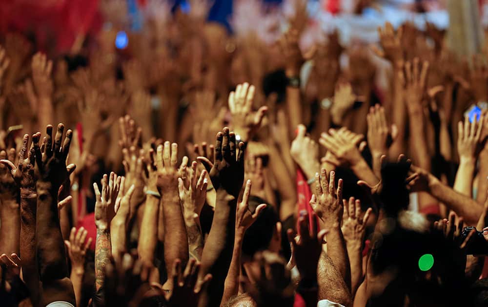 Supporters raise their arms during a rally in support of Brazil's former President Luiz Inacio Lula da Silva and President Dilma Rousseff, in Sao Bernardo do Campo, in the greater Sao Paulo area, Brazil.