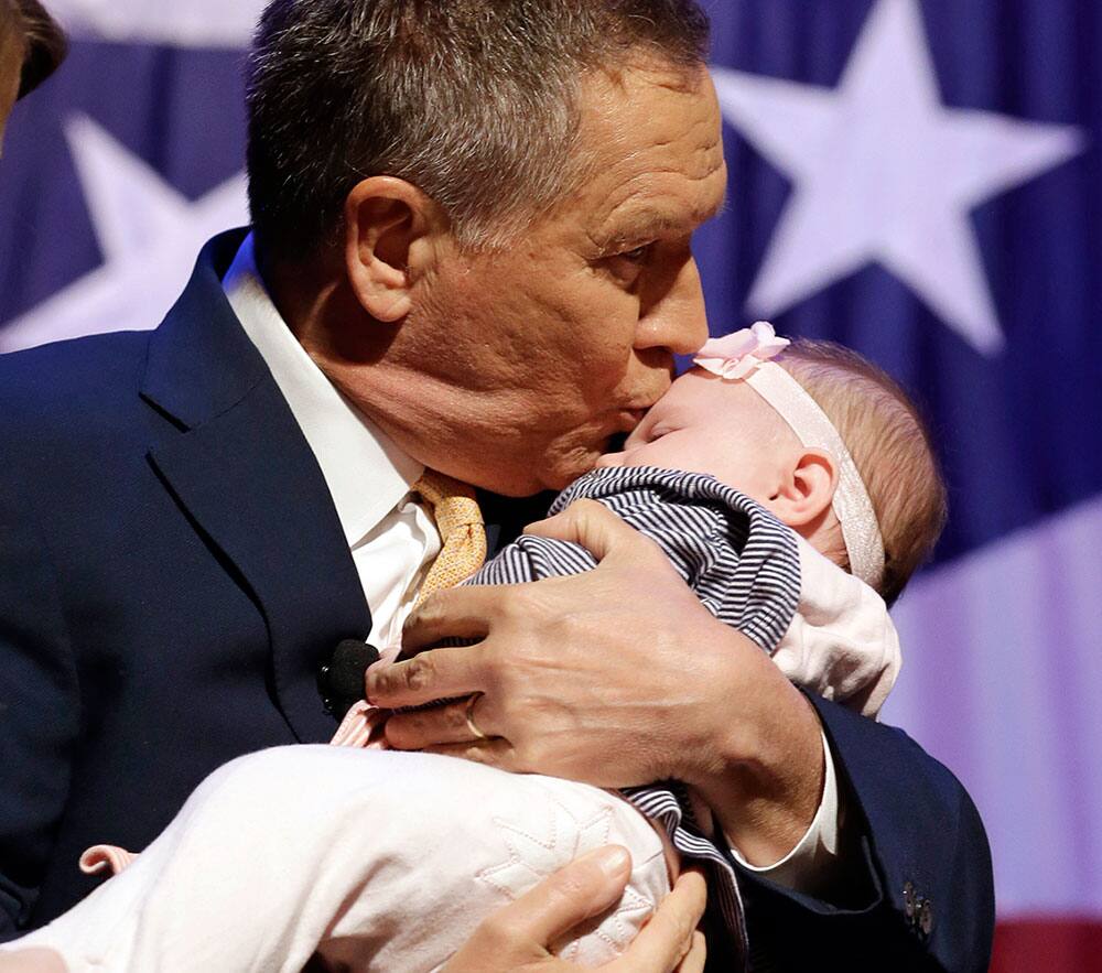 Republican presidential candidate, Ohio Gov. John Kasich kisses four-month old Josaphine Nemeth before delivering the State of the State address at the Peoples Bank Theatre.