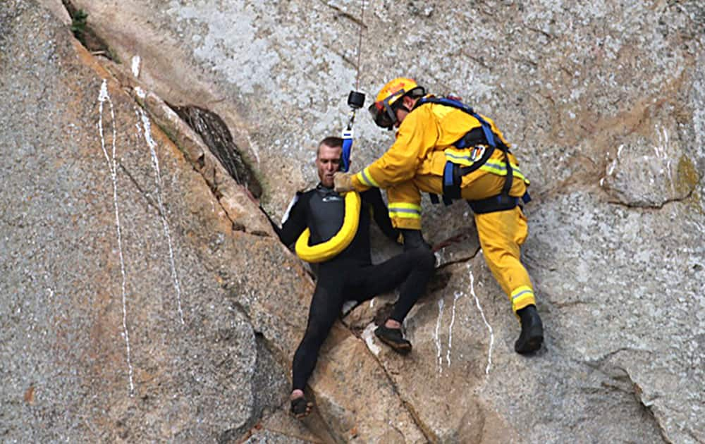 This photo provided by Bob Isenberg, Michael Banks is stranded on a ledge some 80 feet off the ground on Morro Rock, a landmark in Morro Bay, Calif. 