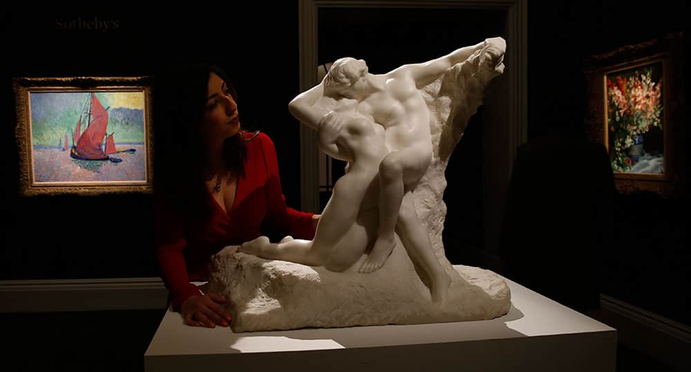 A member of Sotheby's staff poses next to a sculpture by Auguste Rodin entitled 'L'Eternal Printemps' (The Eternal Spring) carved in 1901-2 as it is displayed at Sotheby's auction house in London.