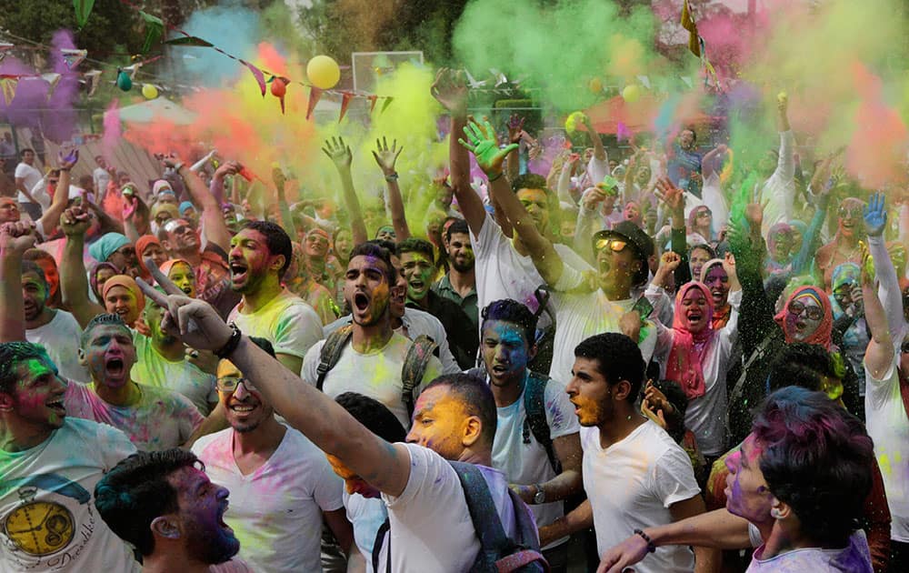 Egyptians toss colored powder into the air during the Festival of Colors organized by the Indian Cultural Center in Cairo, Egypt.