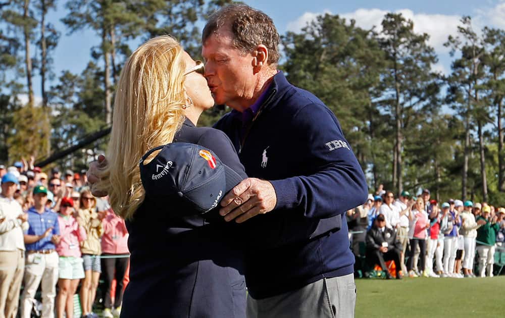 Tom Watson kisses his wife Hilary on the 18th hole after playing his last round at the Masters golf tournament.