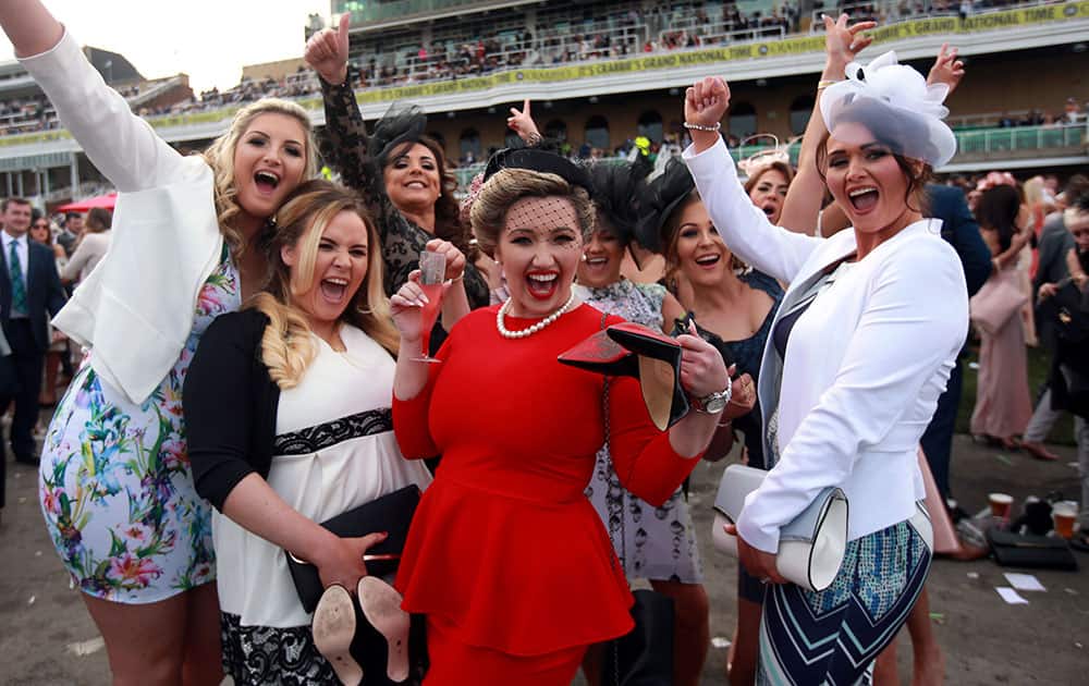 Racegoers pose for a photograph during Ladies Day of the Grand National Festival at Aintree Racecourse, Liverpool, England.