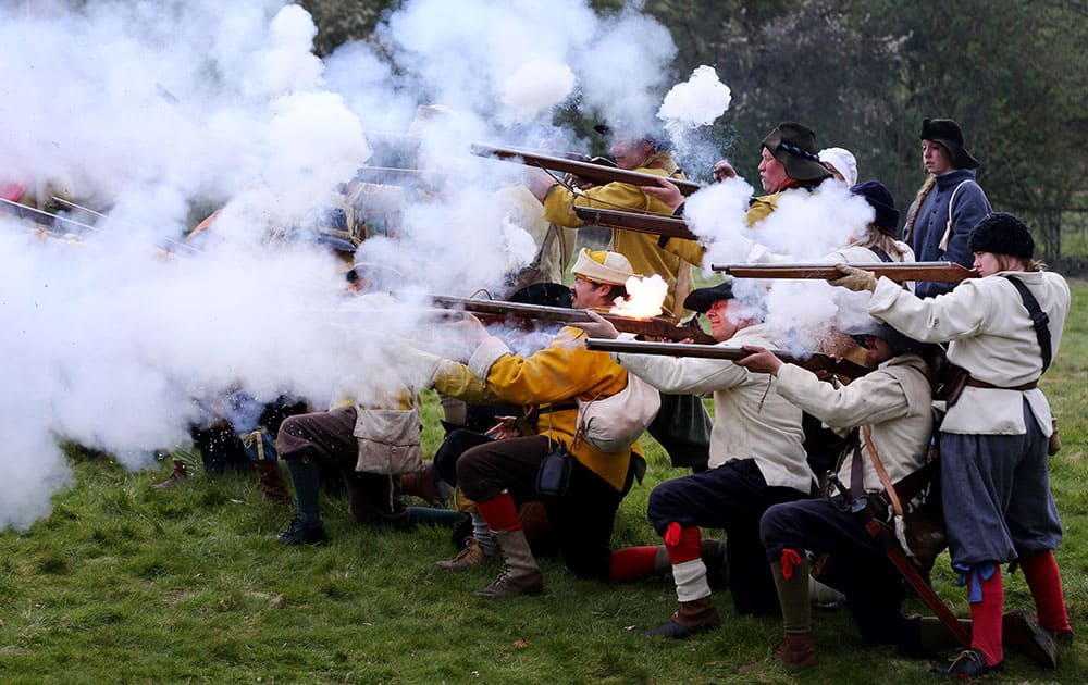 Royalists fire their muskets during a battle against the Parliamentarians as members of The Sealed Knot re-enact the last few hours of the 1645 battle for Basing House, near Basingstoke, England.