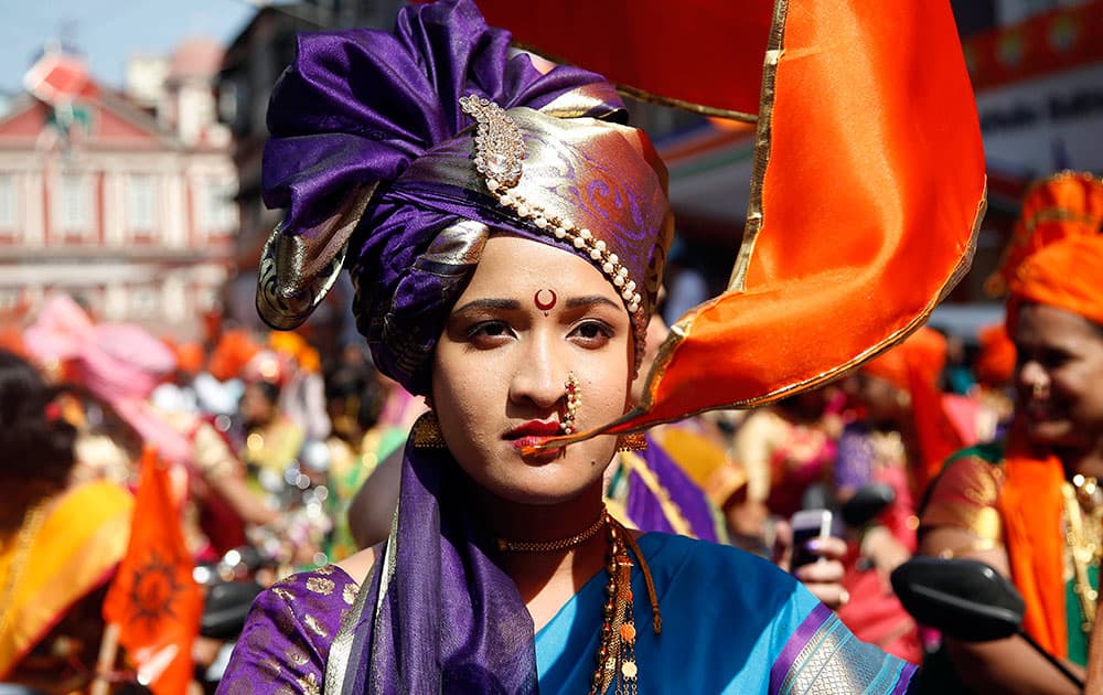 An Indian woman dressed in traditional attire participates in a procession to mark 