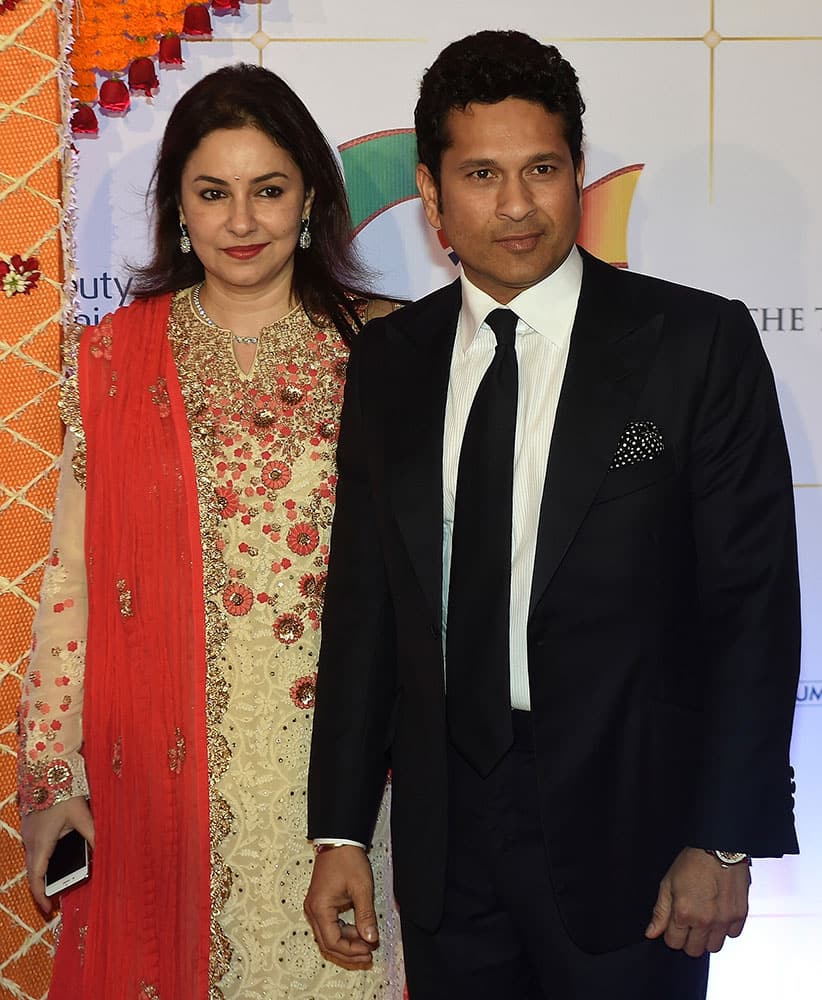 Indian cricketer Sachin Tendulkar and is wife Anjali pose for photographers after arriving for a charity ball at the Taj Mahal Palace hotel attended by the Duke of Cambridge, Prince William, and his wife, Kate, the Duchess of Cambridge, in Mumbai.