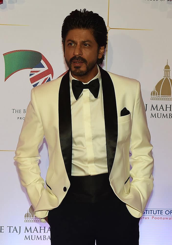 Bollywood actor Shah Rukh Khan poses for photographers after arriving for a charity ball at the Taj Mahal Palace hotel attended by the Duke of Cambridge, Prince William, and his wife, Kate, the Duchess of Cambridge, in Mumbai.