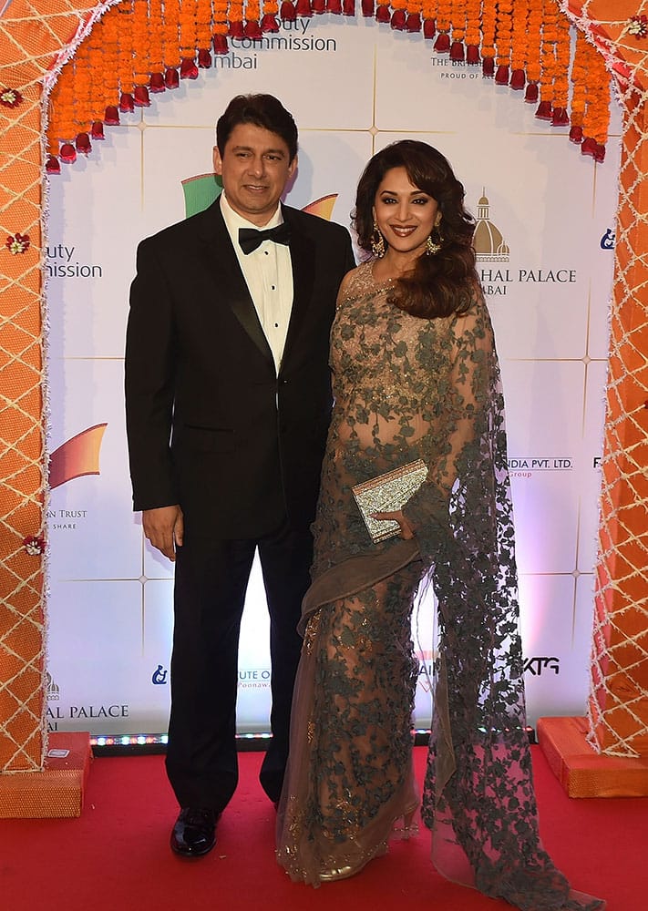 Bollywood actress Madhuri Dixit, right and husband Shriram Nene pose for photographers after arriving for a charity ball at the Taj Mahal Palace hotel attended by the Duke of Cambridge, Prince William, and his wife, Kate, the Duchess of Cambridge, in Mumbai.