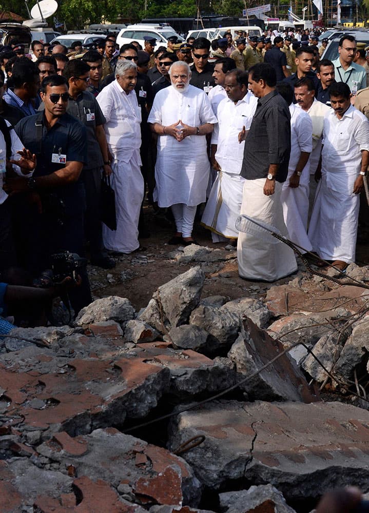 Prime Minister Narendra Modi, center, visits the site after a massive fire broke out during a fireworks display at the Puttingal temple complex in Paravoor village, north of Thiruvananthapuram, southern Kerala state.