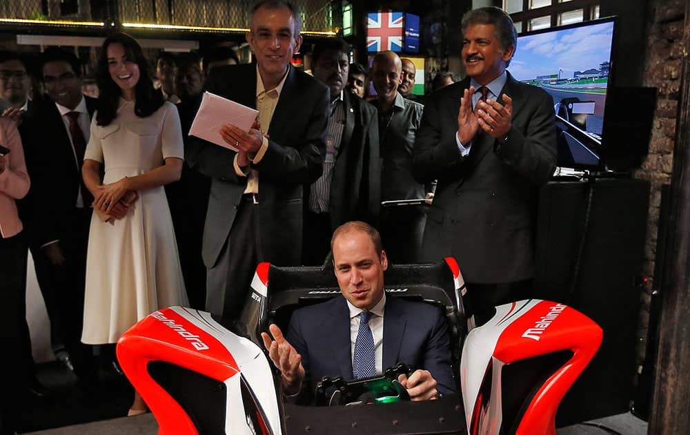 Britain's Prince William steers a Formula E simulator at an event on young entrepreneurs in Mumbai.