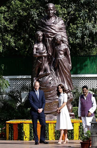 Britain's Prince William, and Kate, the Duchess of Cambridge, walk back after looking at a sculpture of Mahatma Gandhi in New Delhi.
