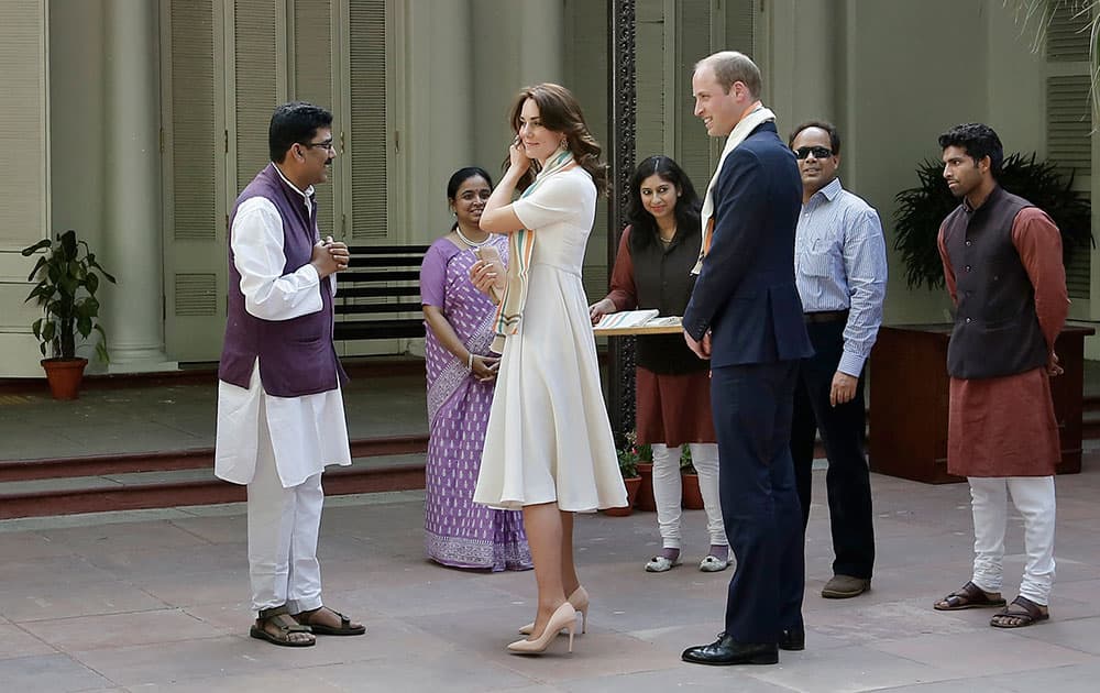 Britain's Kate, the Duchess of Cambridge speaks with a caretaker of Gandhi Smriti as her husband Britain's Prince William looks on during their visit in New Delhi.