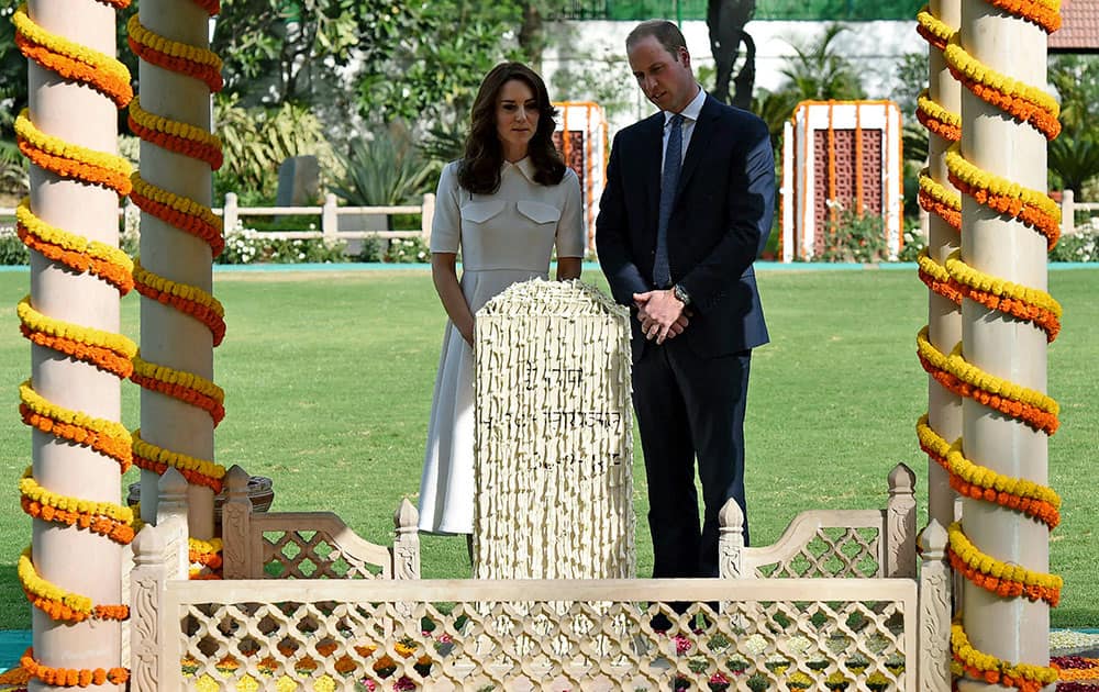 Britain's Prince William, the Duke of Cambridge, and his wife Kate, the Duchess of Cambridge, speak each other as they pay tribute during a visit to Gandhi Smriti, an Indian museum dedicated to Mahatma Gandhi in New Delhi.