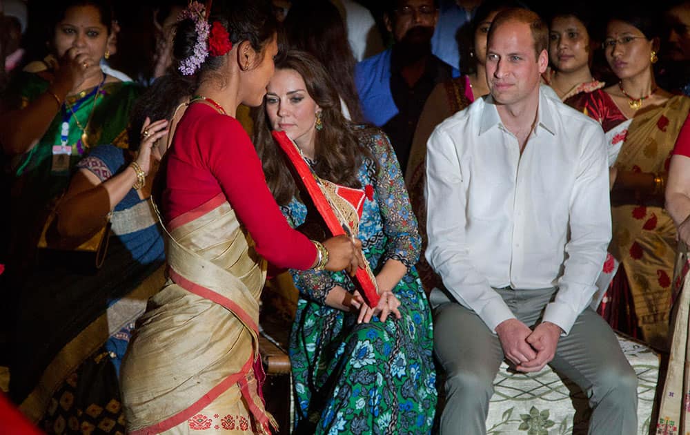 Britain's Prince William along with Kate, the Duchess of Cambridge watch as an Assamese traditional Bihu dancer shows a traditional hat to them in Diphlu River Lodge in the Kaziranga National Park, Assam.