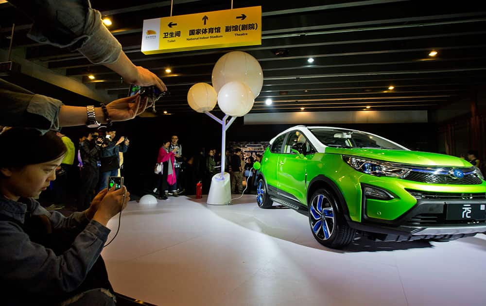 visitors examine the Yuan, BYD's latest Plug-in Hybrid mini SUV introduced at the BYD Dreams Conference in Beijing, China. 