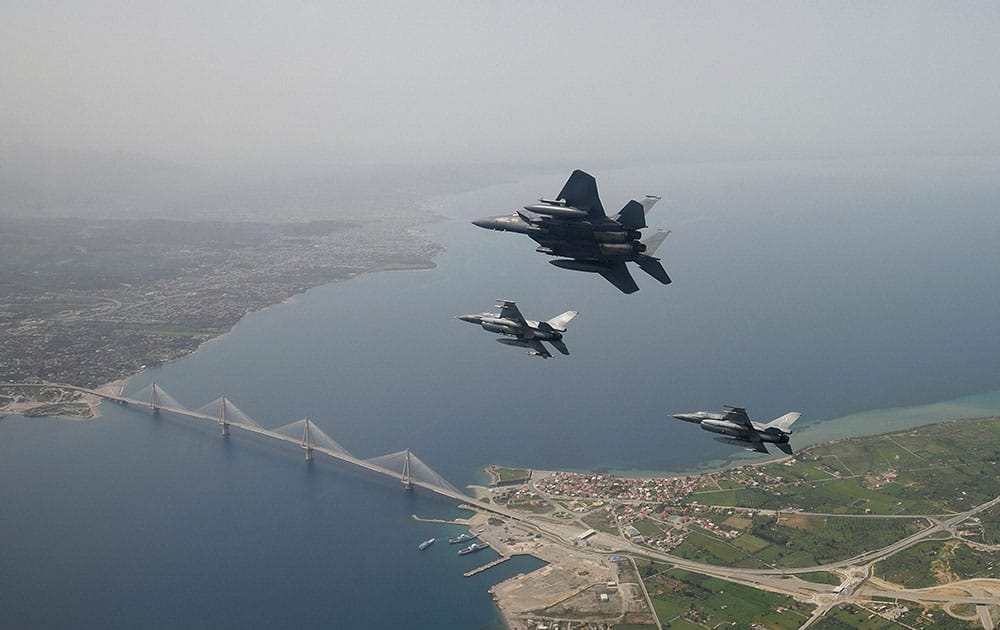 two Greek F-16 fighter jets and a USAF F-15E Strike Eagles, based at Lakenheath airbase in England, fly past the 2,880-meter Rio-Antirrio Bridge in southern Greece.