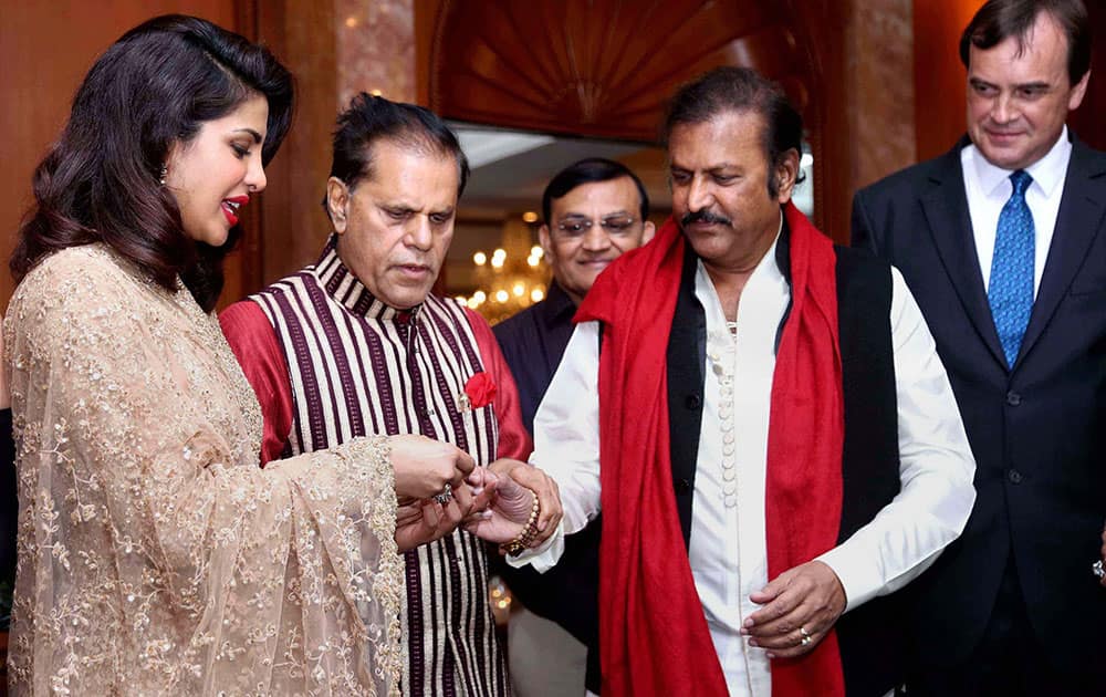 Actress Priyanka Chopra (L) after being presented golden bangles by South Indian actor-director Mohan Babu at a get-together function organised by Rajya Sabha Member T Subbarami Reddy (2nd L) to felicitate the actress on being honored with Padma Shri Award in New Delhi.
