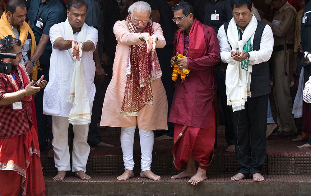 Prime Minister Narendra Modi offers prayers at a holy pond inside the Kamakhya temple in Gauhati. Modi is on an election campaign tour for the second and final phase of state Assembly elections.