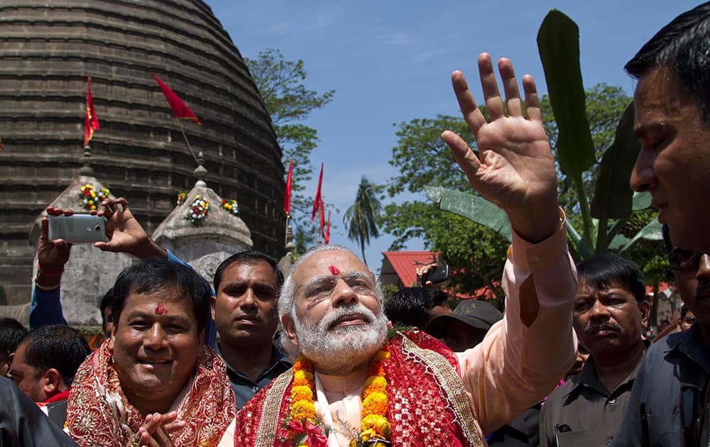Prime Minister Narendra Modi waves to his supporters after offering prayers at Kamakhya temple in Guwahati. Modi is on an election campaign tour for the second and final phase of state Assembly elections. 