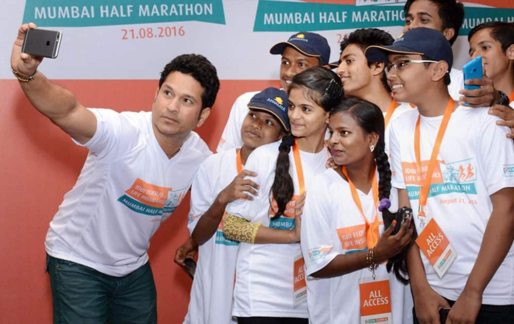 Cricket legend Sachin Tendulkar takes selfie with the children during announcement of IDBI Federal Life Insurance Mumbai Half Marathon in Mumbai.