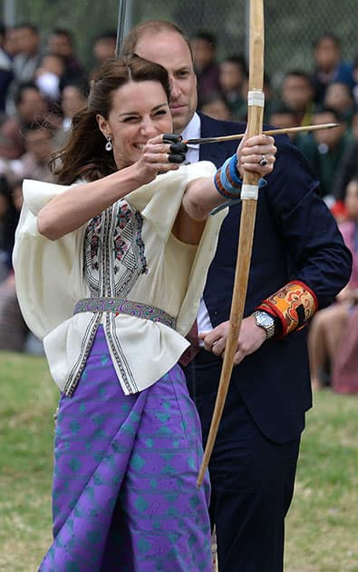 Kate Duchess of Cambridge takes part in an archery event as her husband Prince William looks over her shoulder in Thimphu, Bhutan, during day five of the royal tour to India and Bhutan.