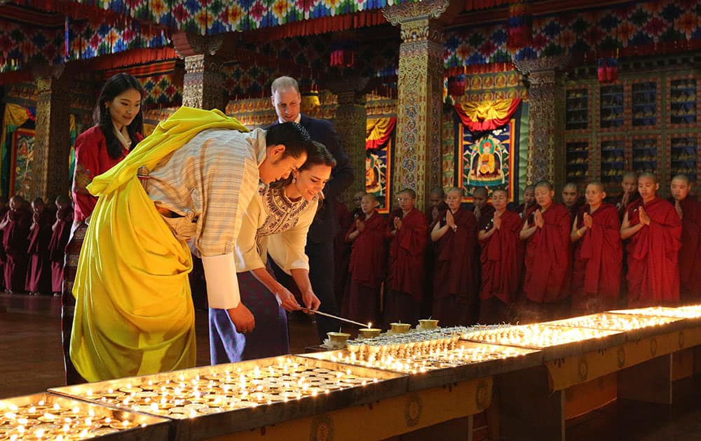 Royal Kingdom of Bhutan, Kate, Duchess of Cambridge, is helped by Bhutan's King, Jigme Khesar Namgyel Wangchuk, as she lights up an oil lamp in Thimphu, Bhutan.