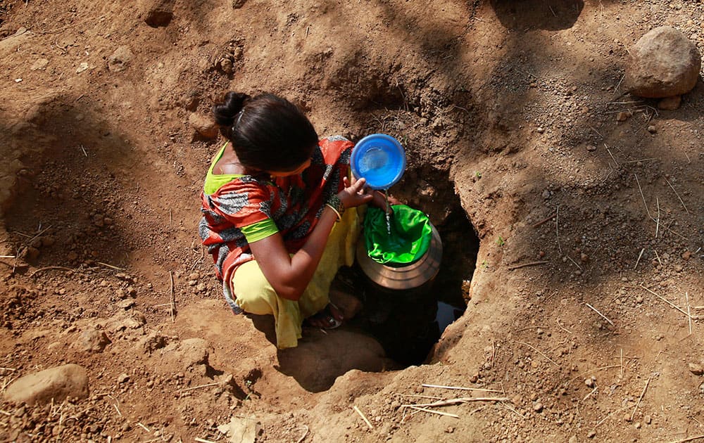 A woman collects water from a spring at Raichi Wadi village, 120 kilometers (75 miles) north-east of Mumbai. Decades of groundwater abuse, populist water policies and poor monsoons have turned vast swaths of central and western India into a dust bowl, driving distressed farmers to suicide or menial day labor in the cities.