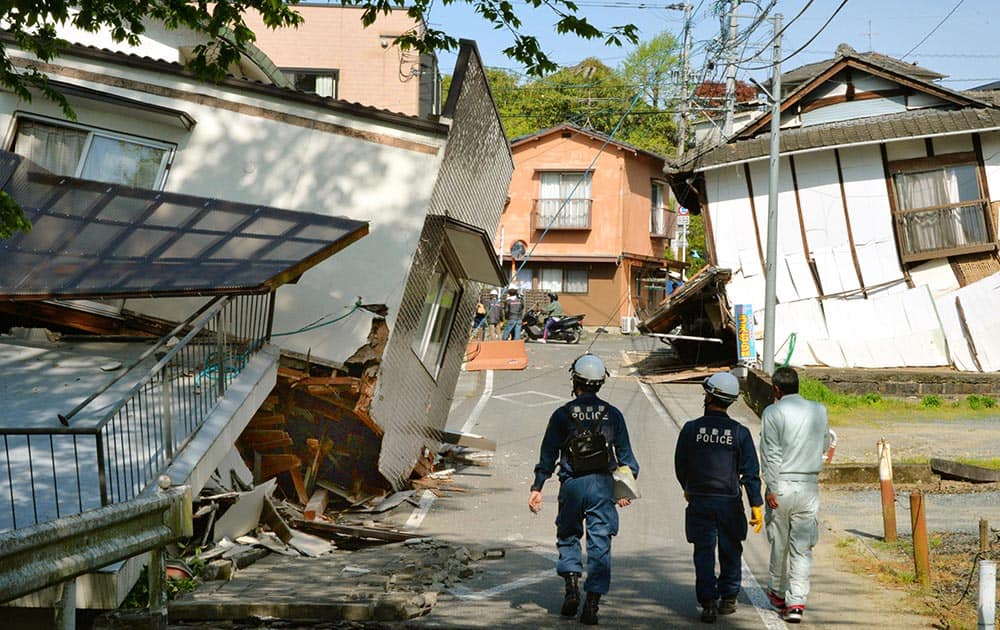 Riot policemen examine the damage of houses collapsed by a magnitude-6.5 earthquake in Mashiki, Kumamoto prefecture, southern Japan.