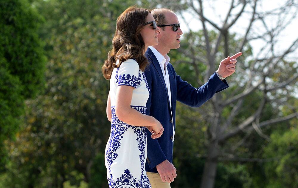 Britain's Prince William, along with his wife, Kate, the Duchess of Cambridge, gestures as they walk during their visit to the Taj Mahal in Agra, India.